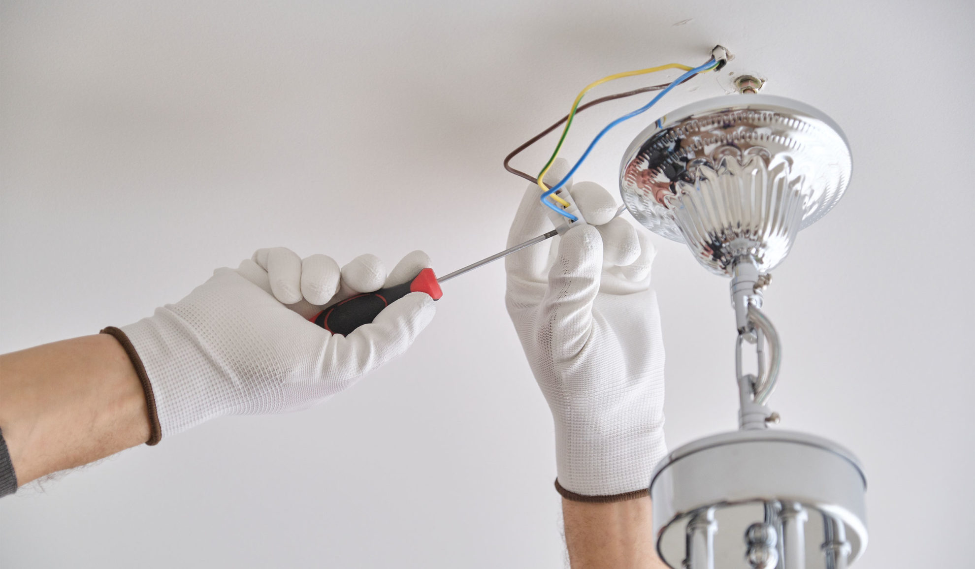 contractor-hands-with-gloves-and-screwdriver-close-up-repairing-ceiling-lamp-auburn-ca