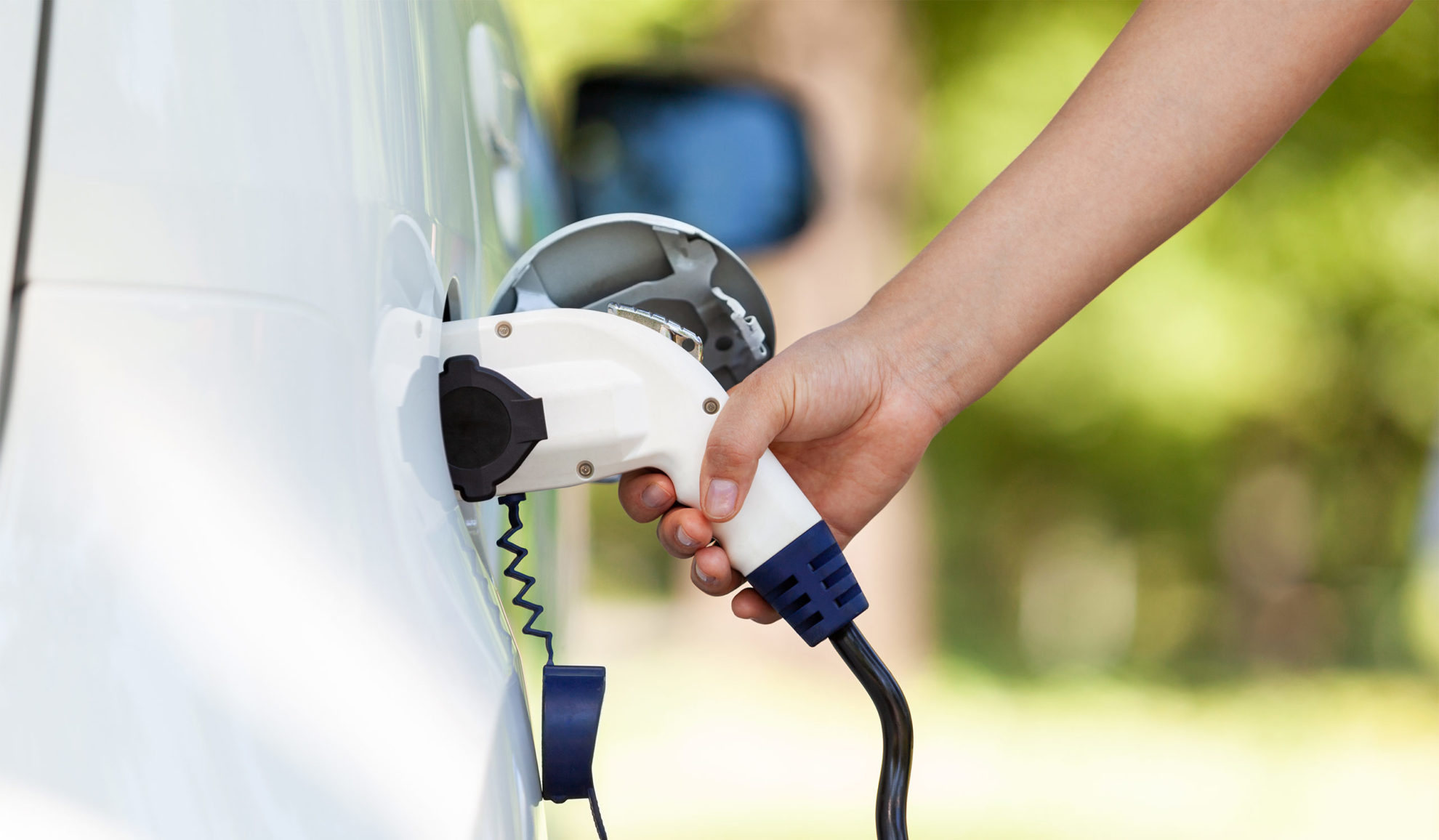 woman-hand-close-up-installing-ev-charger-to-electric-car-close-up-at-exteriors-auburn-ca